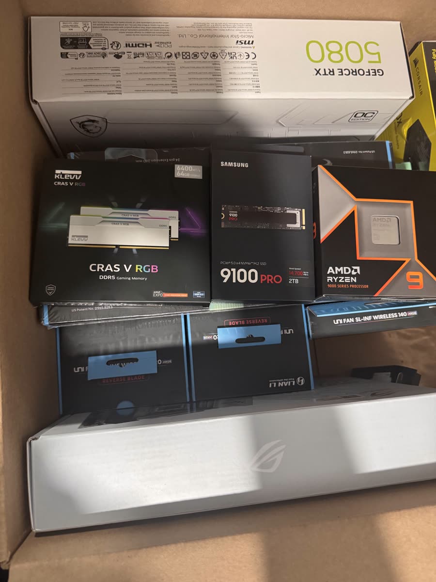 Crate of new PC component boxes: GeForce RTX 5080, Ryzen 9, Samsung 9100 PRO SSD, KLEVV DDR5 memory