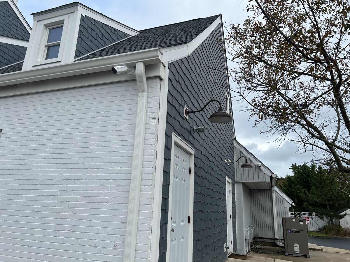 Weatherproof security camera mounted under the front-right eave near the entrance of Venus Nails Salon